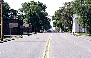 Roxana, Illinois was only 2 blocks wide in the downtown area. Holiday activities and 50s Barber shop brick building on left drug store on the right childhood memories take shape in the neighborhood.