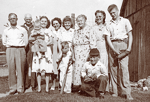 bats and gloves in a family photo demonstrate the prominence of baseball culture
