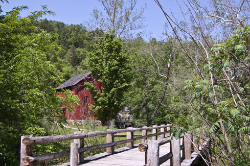 Alley Spring Ozark watermill on a dusty dirt road provided commerce social connections and 50s childhood backroad memories of ancestor solitude and beauty 19th century family traditions promoted 50s childhood backroad memories and family relationships